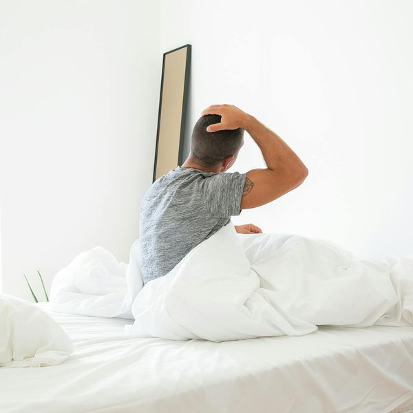 Person stretching peacefully in a room with soft morning light.